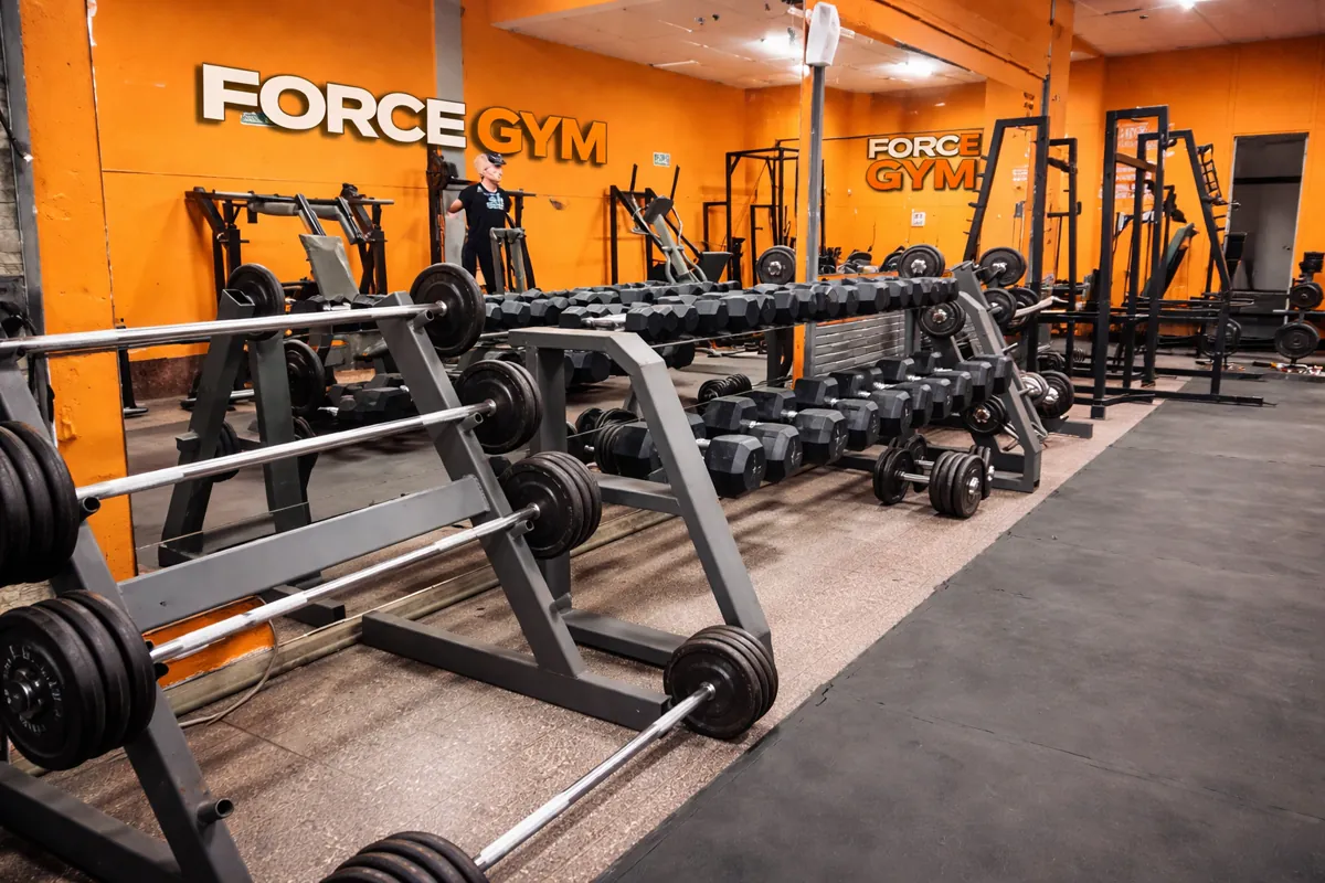 Zona de pesas del gimnasio ForceGym en Montevideo, con racks de potencia y mancuernas